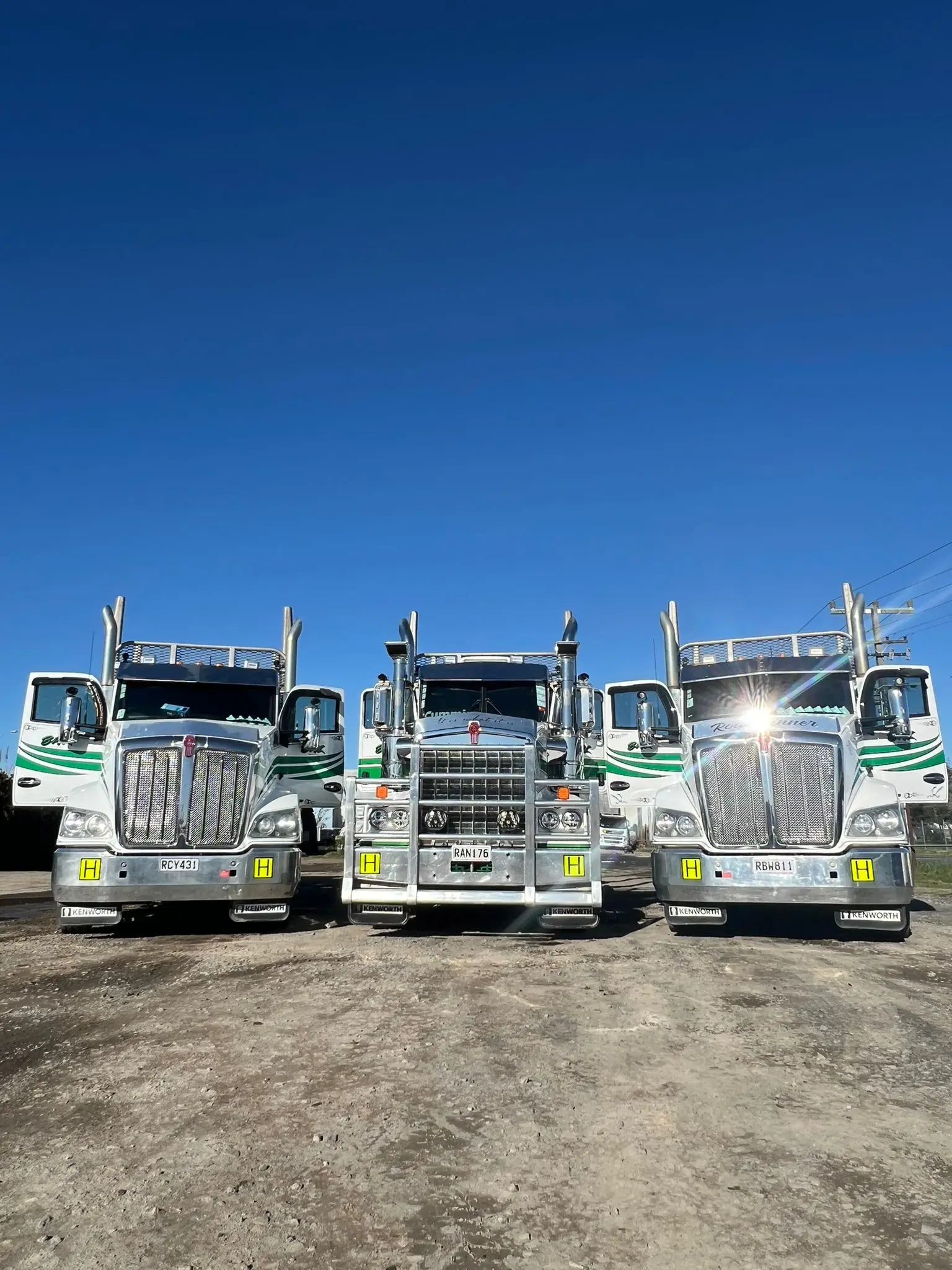 Three BHL Kenworth trucks lined up front-on under a clear sky